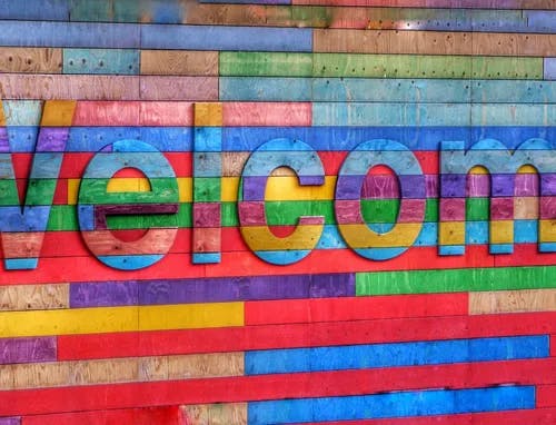 Wooden rainbow sign with Welcome.