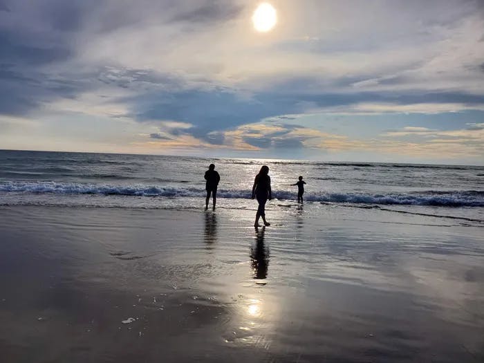 Three people at the beach.
