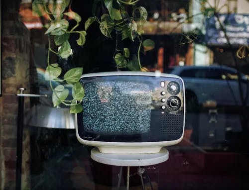 A shop window with an old television showing static. 