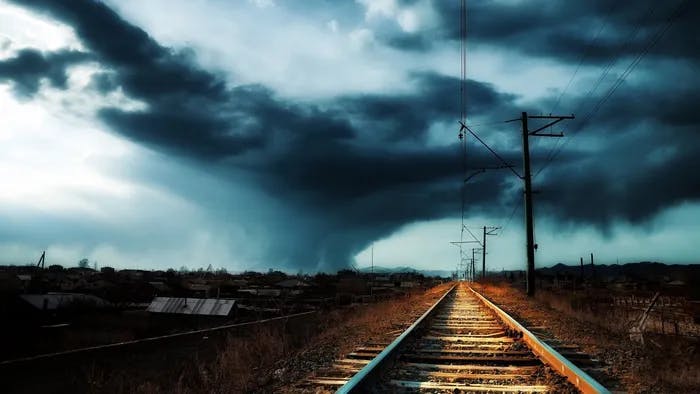 a train track with a dark sky in the background