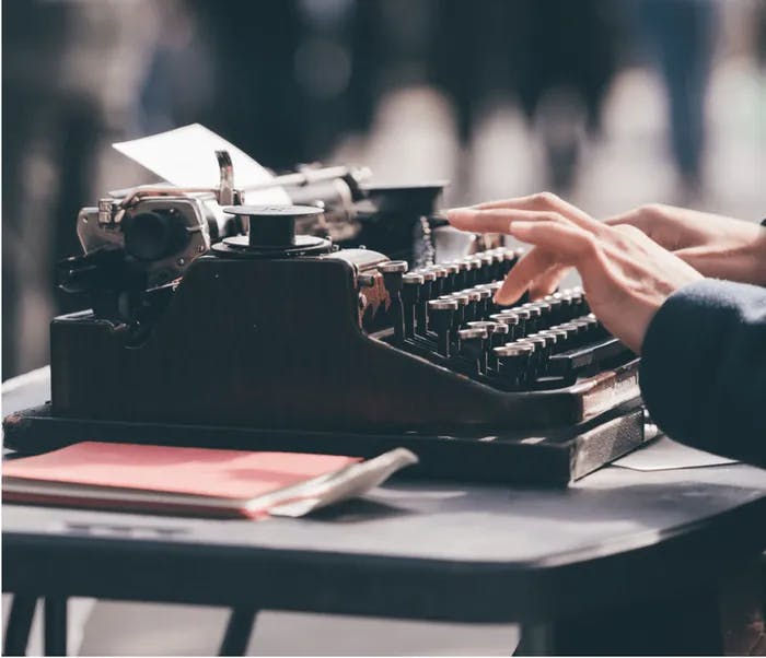 A person typing on a typewriter. 