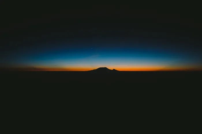 the sun setting over a mountain
