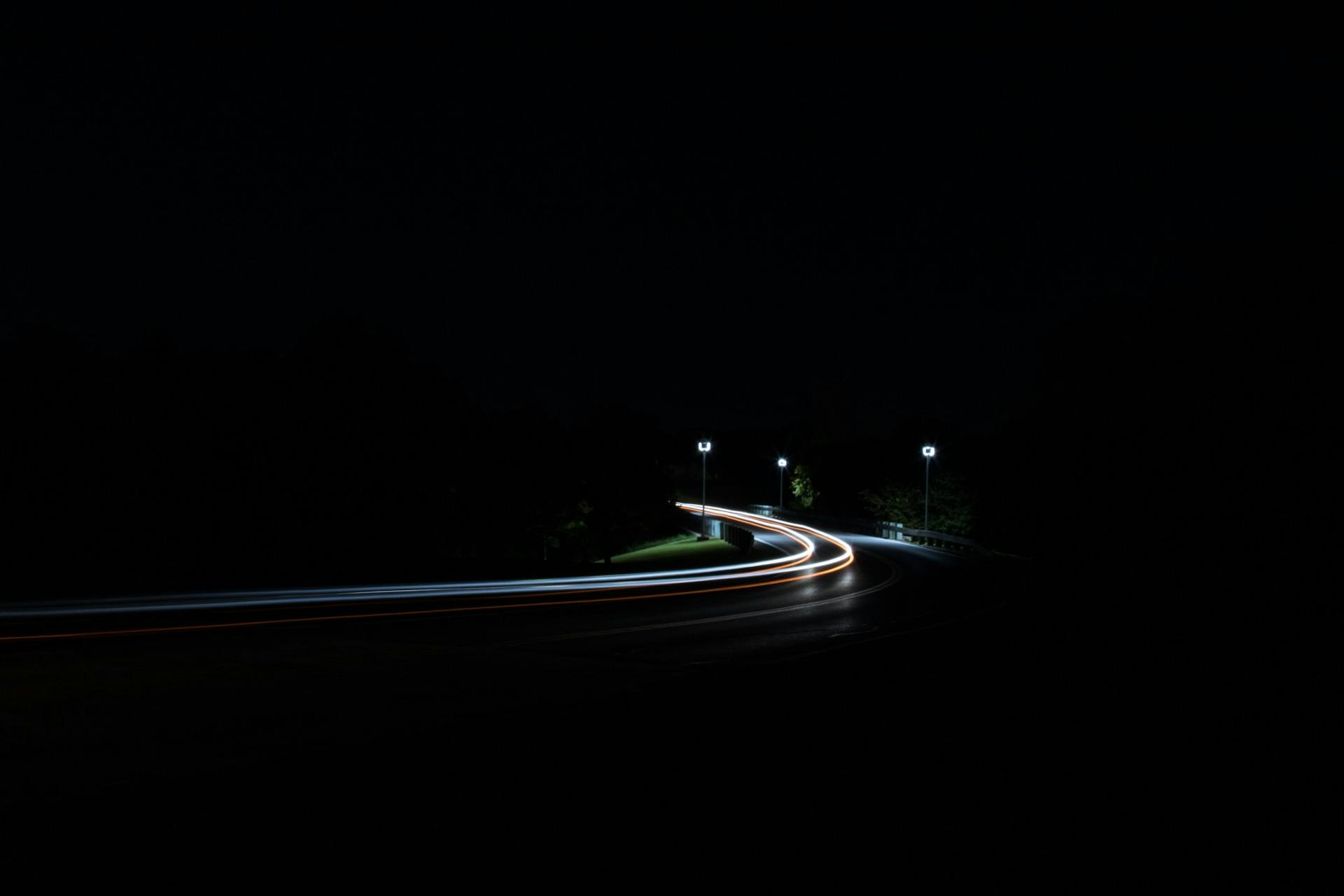Long exposure lights on a road with lamposts.
