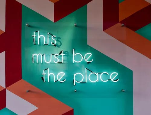 A neon sign with the text "this must be the place".