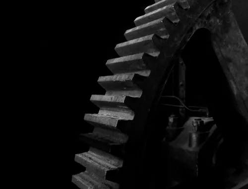 A closeup of a gear in a dark space.