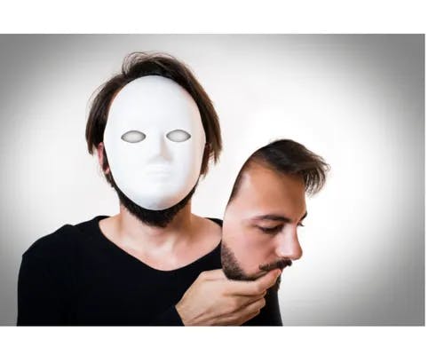 A man holding his face in his hand while his face is blank.