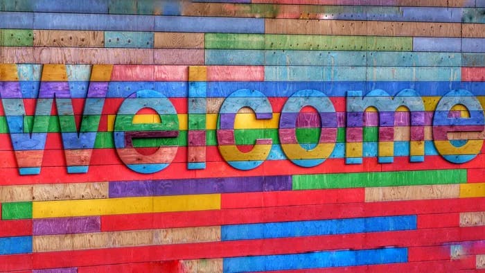Wooden rainbow sign with Welcome.