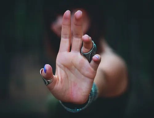 A person holding up their hand to the camera. 