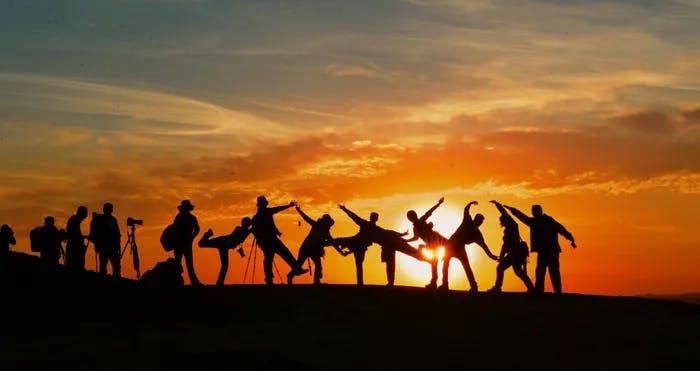 People dancing in-front of sunset