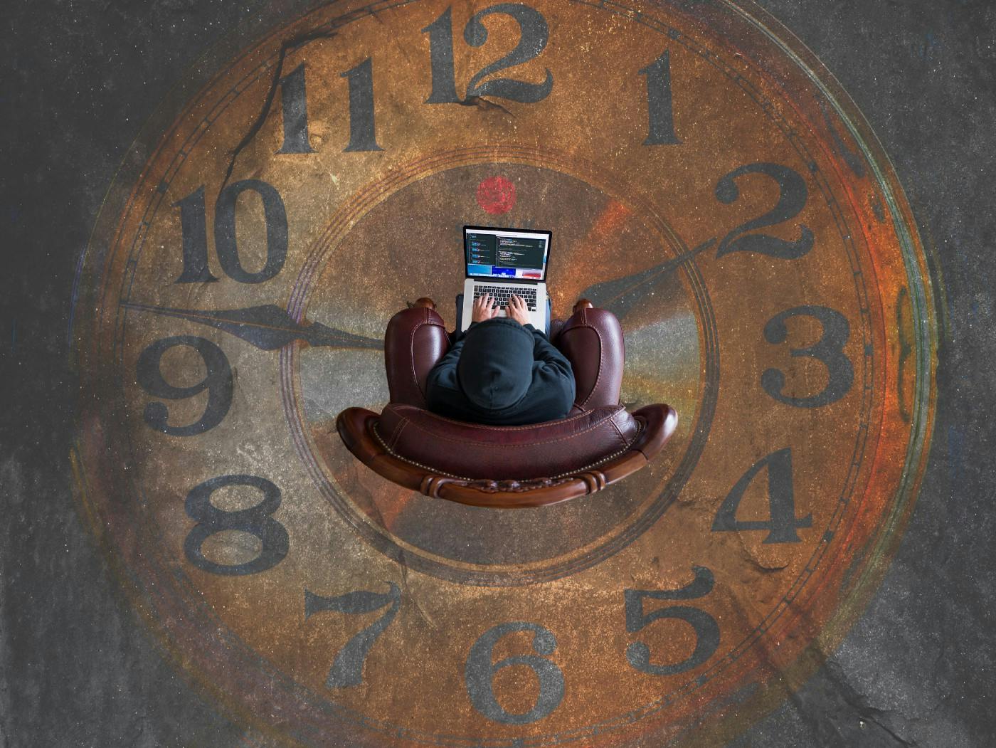 Person sitting with laptop in the middle of a clock painting