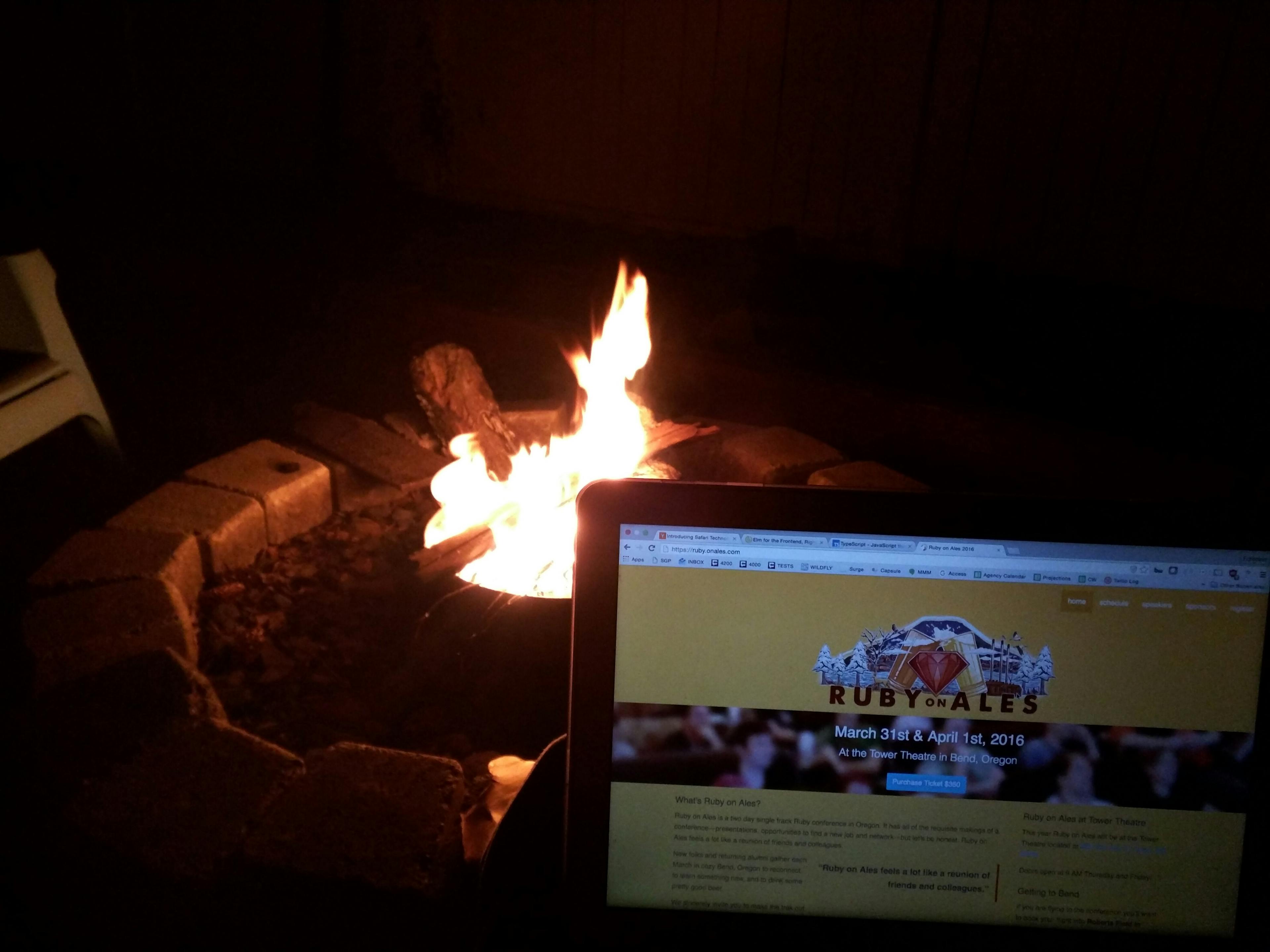 Sitting by a campfire with a laptop