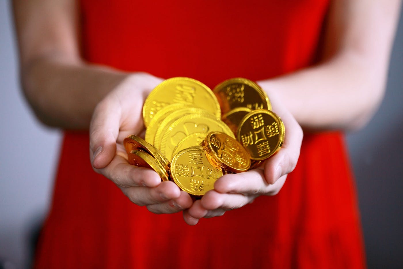 person holding gold-colored coins